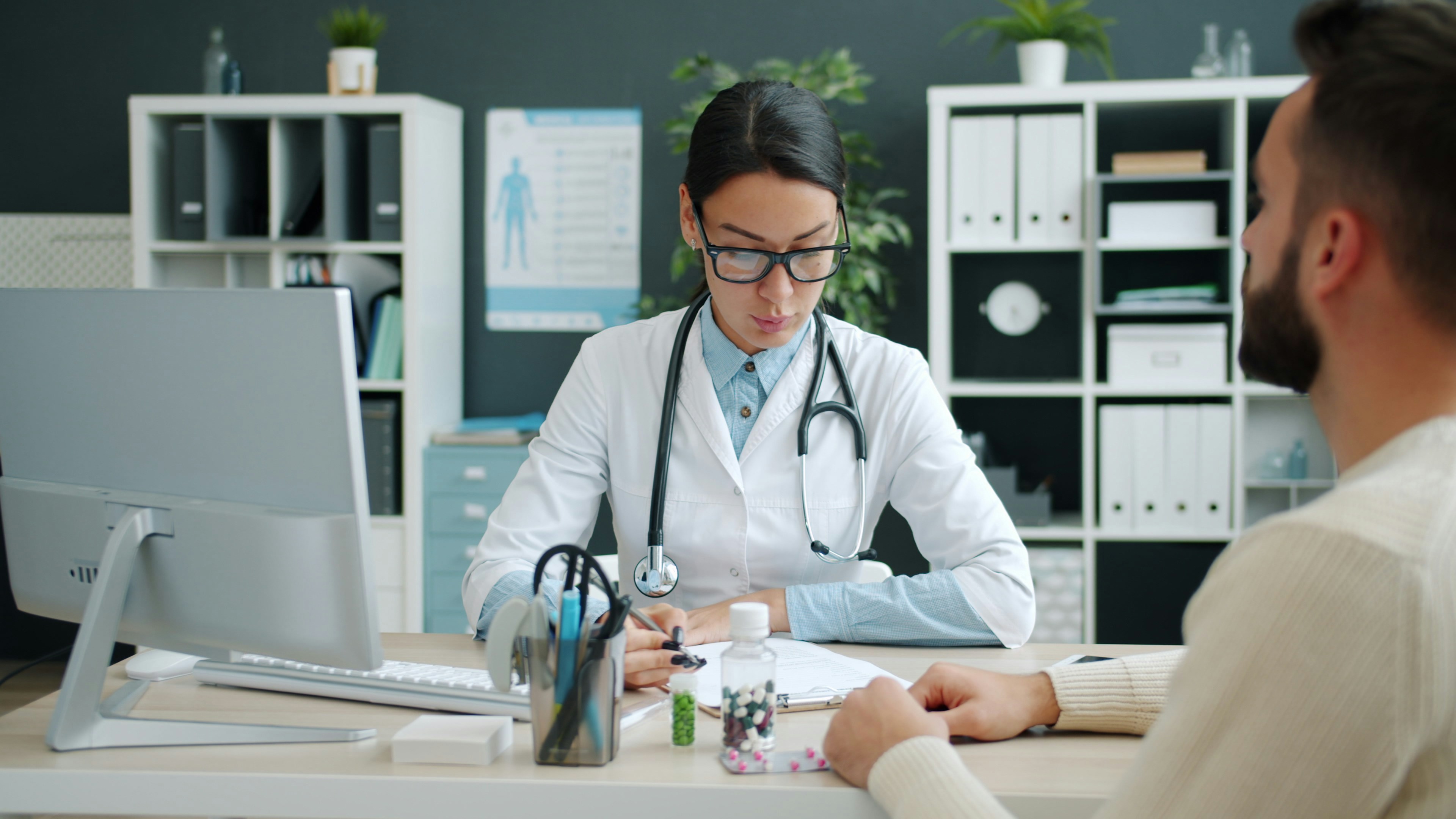 Billing specialist reviewing claims with a physician
